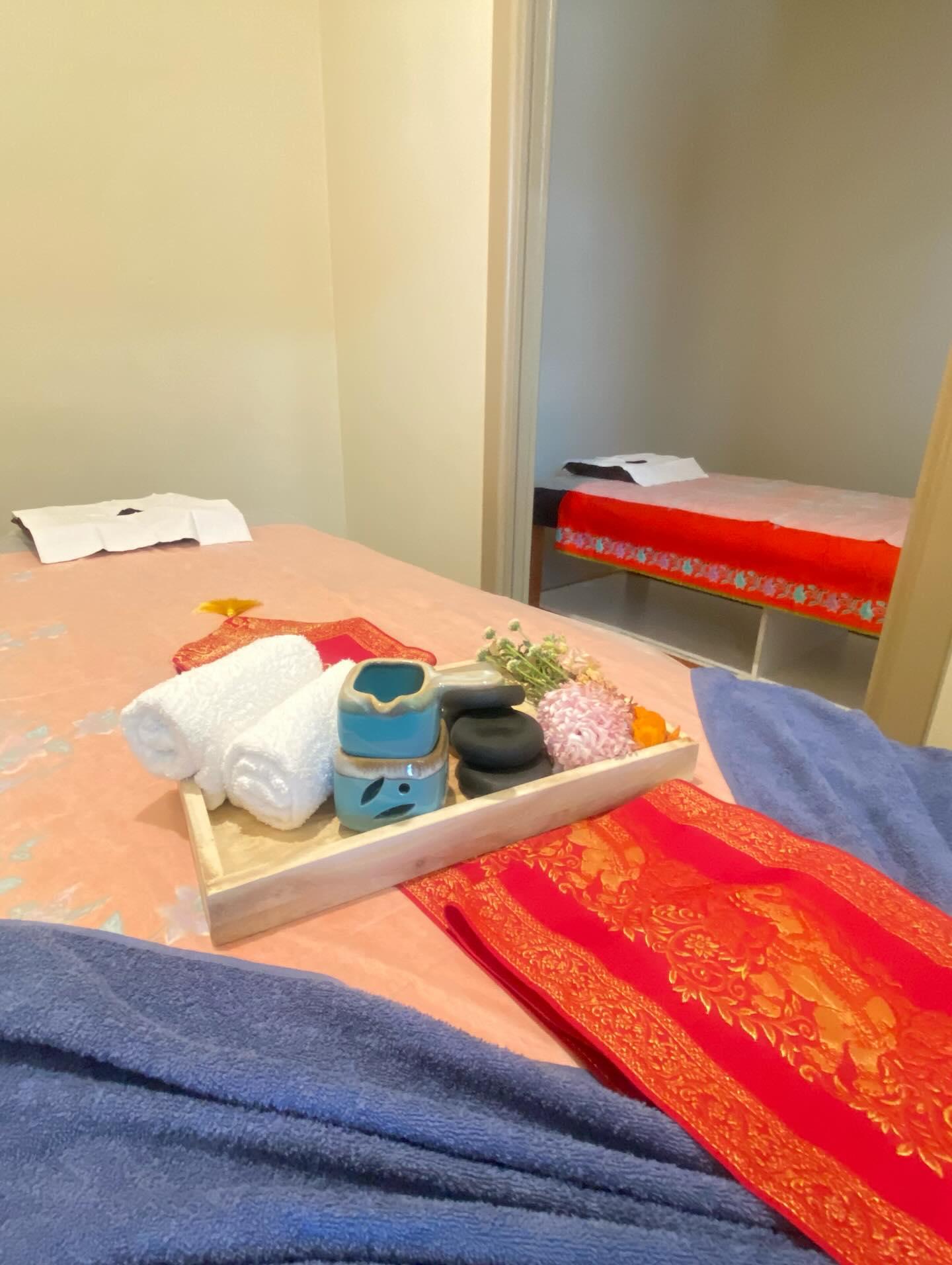Massage room with traditional Thai textiles and hot stones